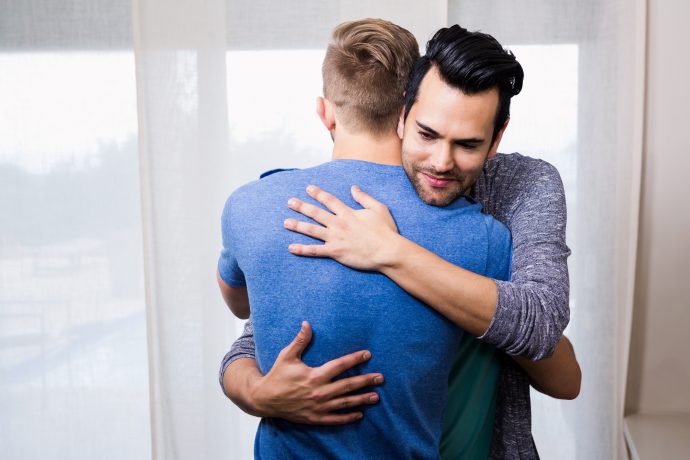 Smiling gay couple embracing