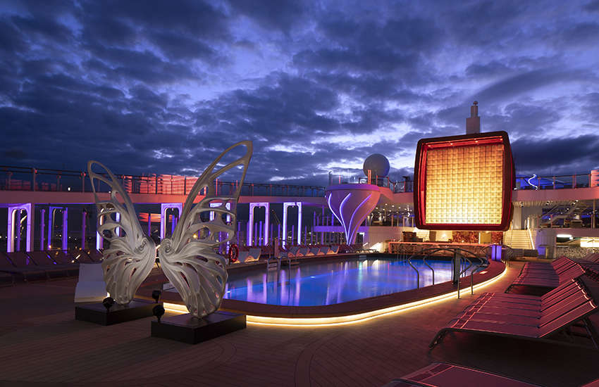 Pool Deck at night with butterfly sculpture.